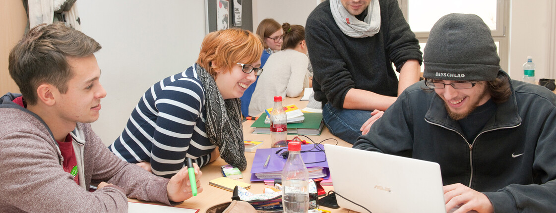 Schüler sitzen über Laptop