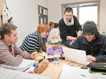 Schüler sitzen über Laptop